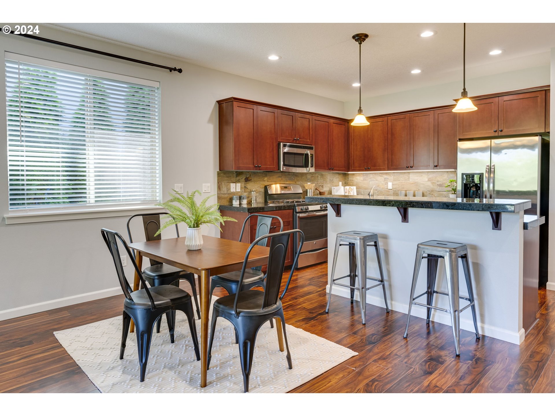 264 North Green Gables Loop Ridgefield, WA 98642 - Photo 14 of 46 a kitchen with stainless steel appliances kitchen island granite countertop a dining table chairs and a refrigerator