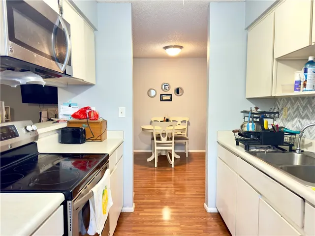 a kitchen with a sink cabinets and wooden floor