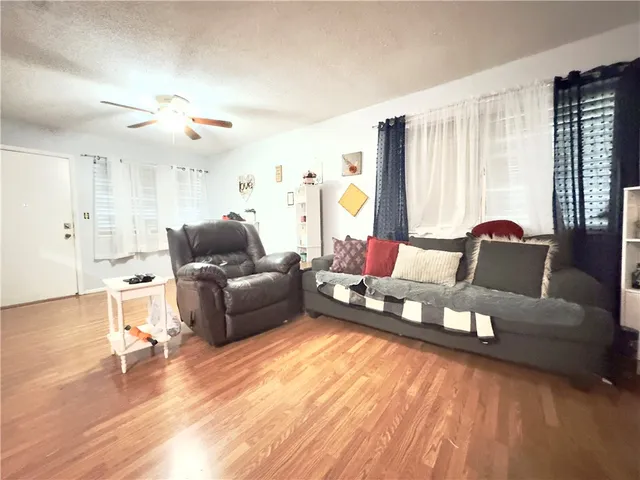 a living room with furniture and wooden floor