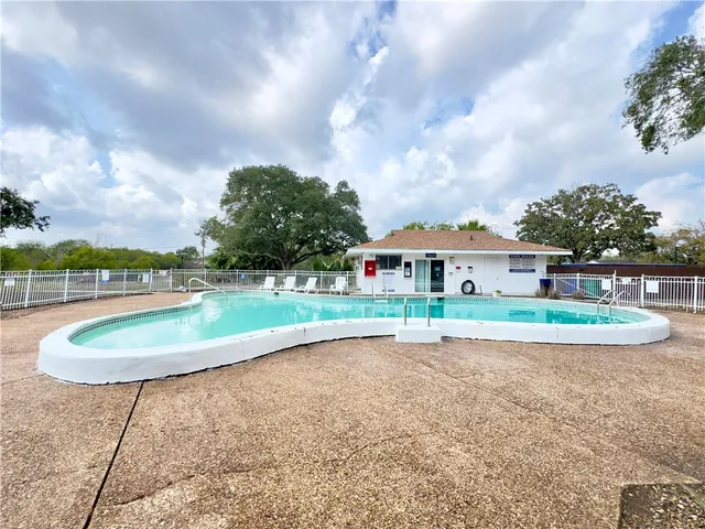 a view of a house with a swimming pool and a yard