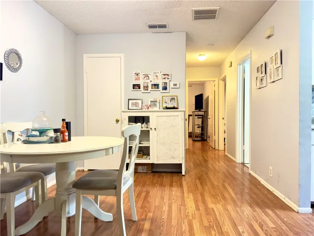 a kitchen with a wooden floor and chairs