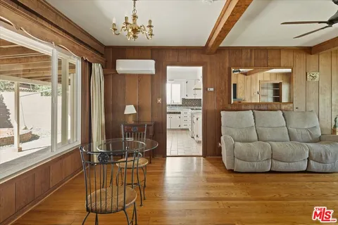 a view of a livingroom with furniture wooden floor and a chandelier