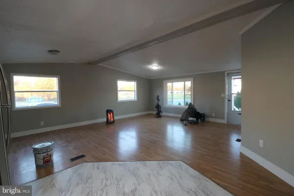 a view of a living room with hardwood floor and windows