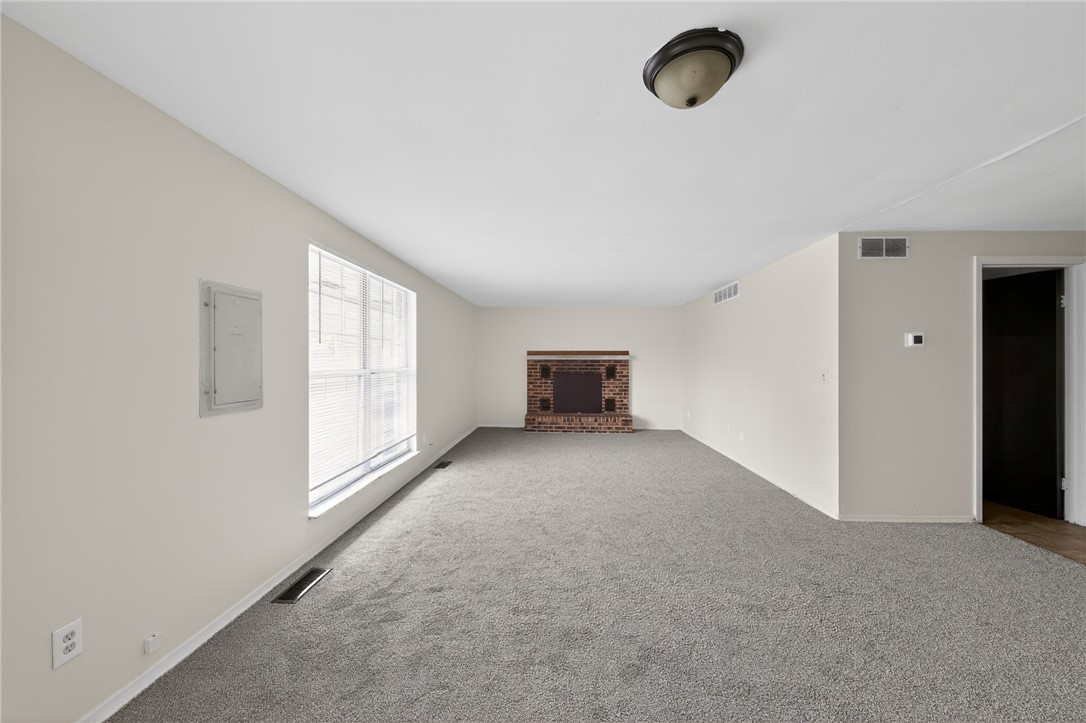 6070 Charlesgate Road Huber Heights, OH 45424 - Photo 14 of 29 This expansive room features a cozy brick fireplace, offering a warm and inviting atmosphere.