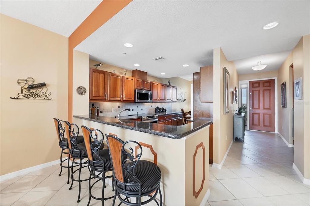 13113 Gasparilla Road, Unit 403 Placida, FL 33946 - Photo 12 of 62 a kitchen with stainless steel appliances kitchen island granite countertop a table chairs sink and cabinets