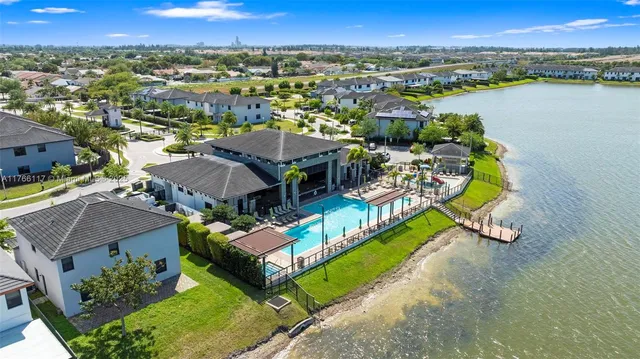 an aerial view of a house with swimming pool and lake view