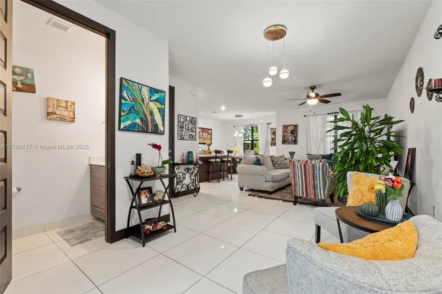 a living room with furniture potted plant and flat screen tv