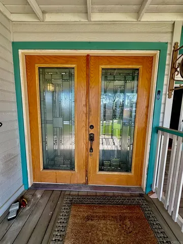 a front view of a house with a yard and potted plants