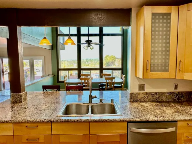 a kitchen with granite countertop a sink and a large window