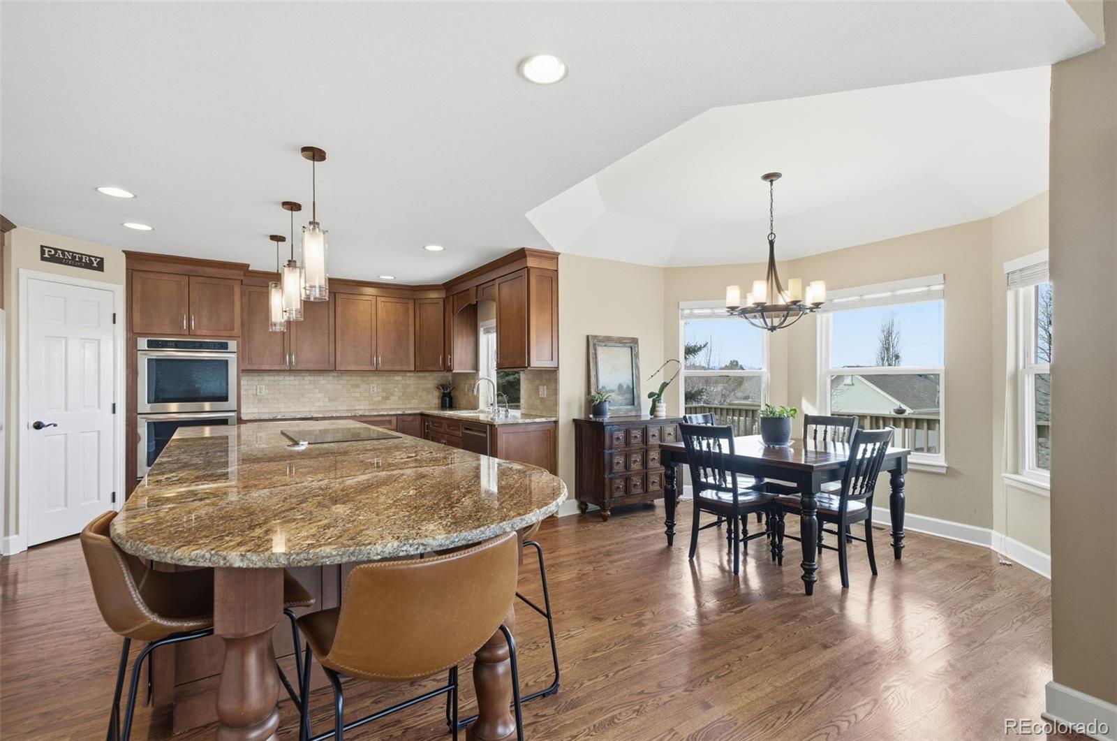 6879 Ingleton Drive Castle Pines, CO 80108 - Photo 16 of 50 a view of a dining room with furniture window and wooden floor