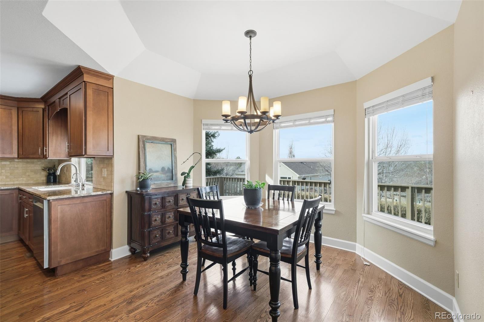 6879 Ingleton Drive Castle Pines, CO 80108 - Photo 19 of 50 a view of a dining room with furniture window and wooden floor
