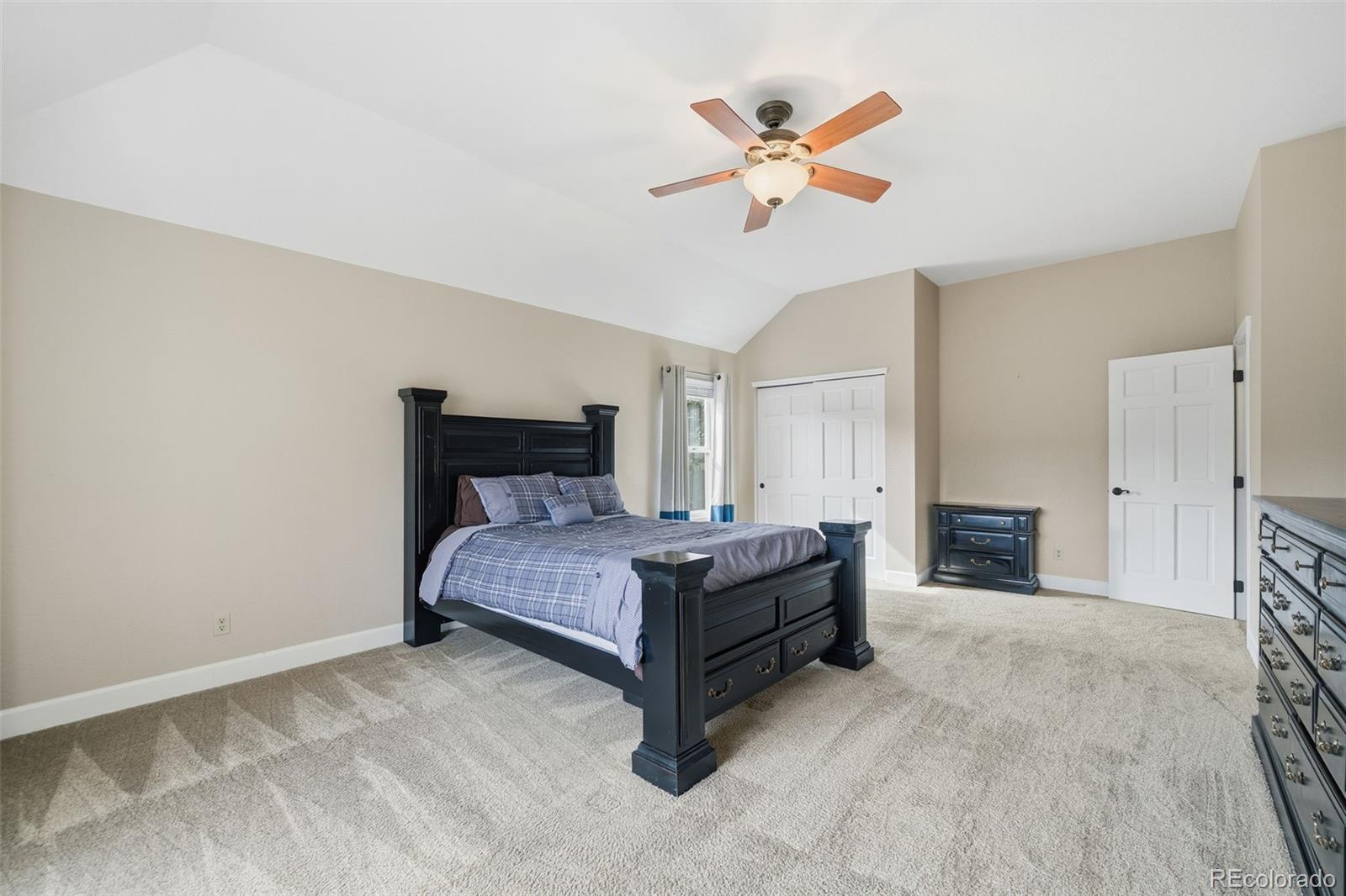 6879 Ingleton Drive Castle Pines, CO 80108 - Photo 22 of 50 a bedroom with a bed and a chandelier