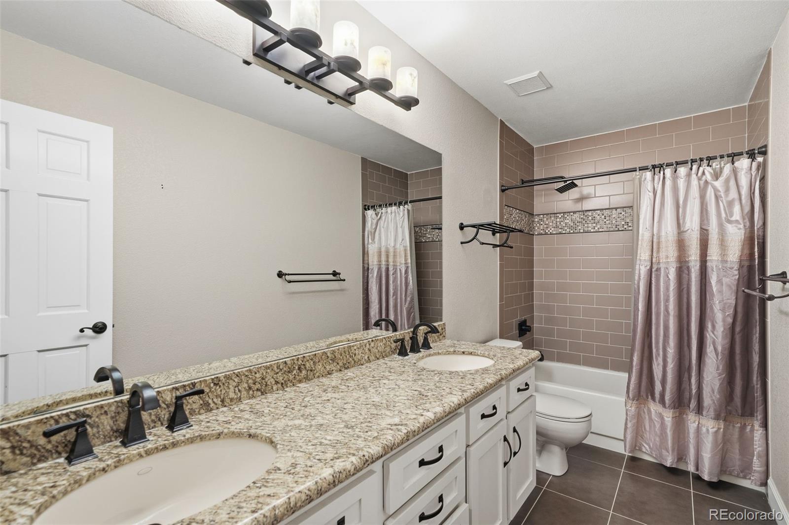 6879 Ingleton Drive Castle Pines, CO 80108 - Photo 28 of 50 a bathroom with a granite countertop sink a toilet and shower