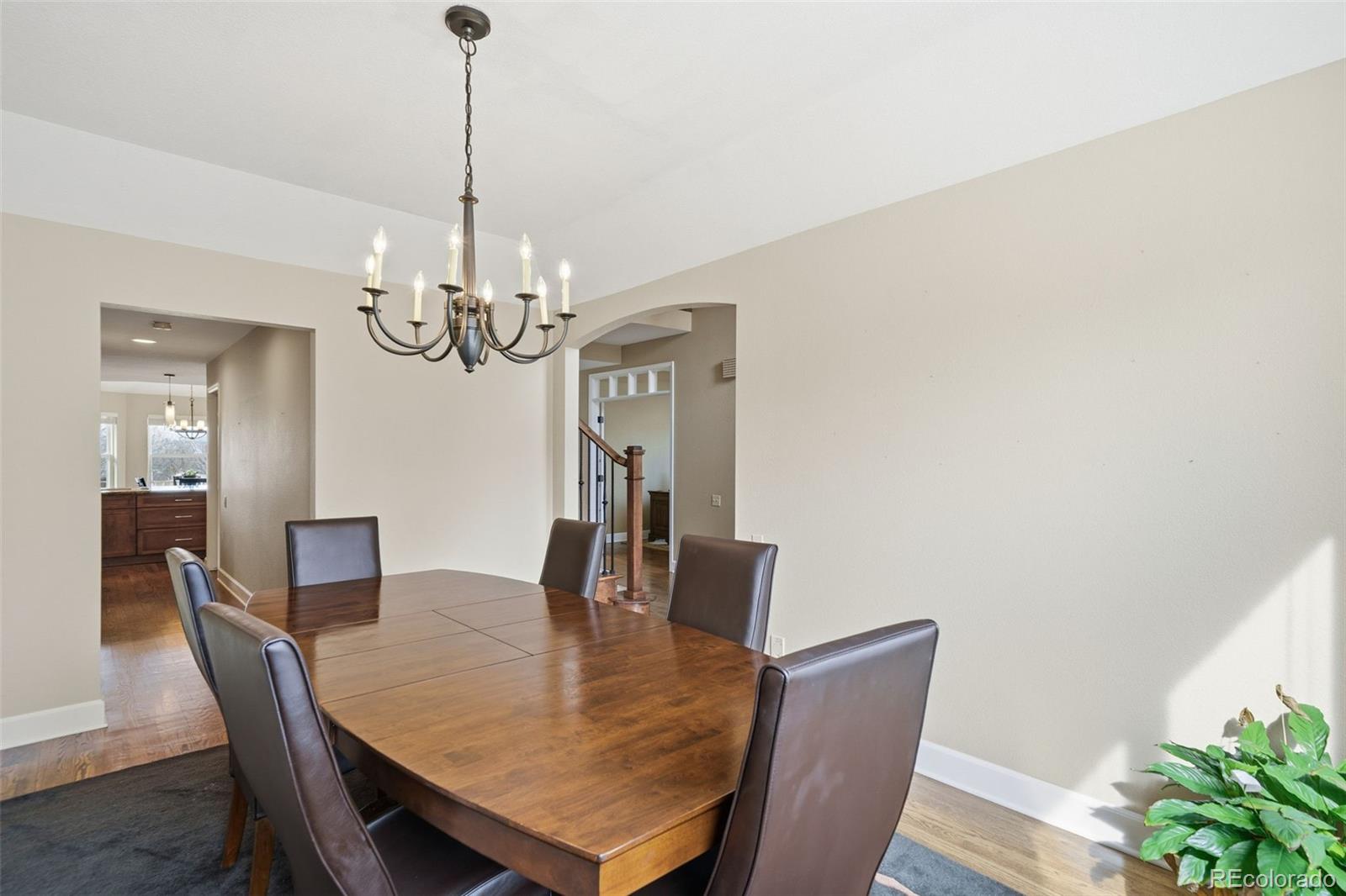 6879 Ingleton Drive Castle Pines, CO 80108 - Photo 9 of 50 a dining room with furniture a chandelier and wooden floor