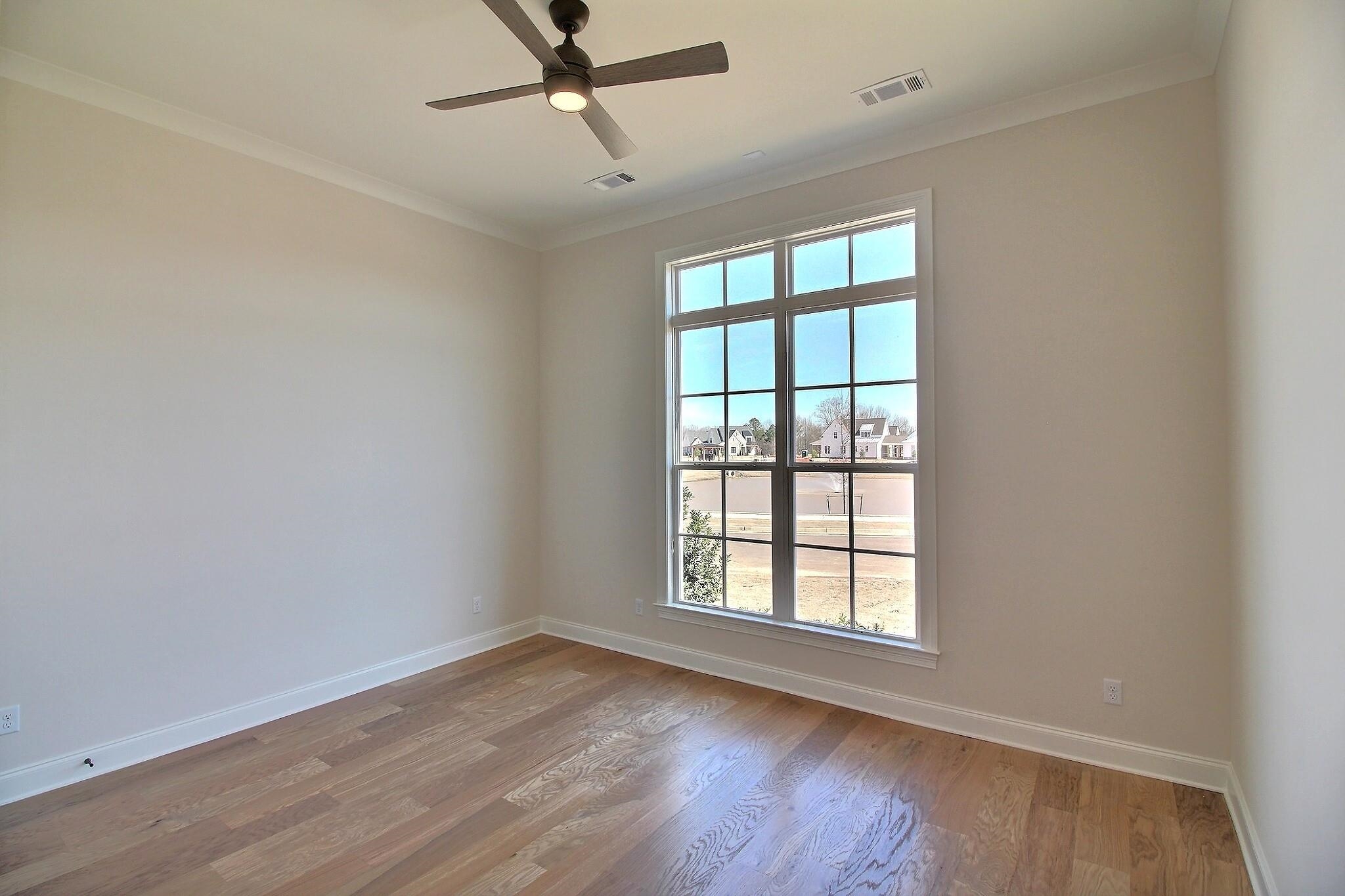 110 Rambling Rex Trail Collierville, TN 38017 - Photo 21 of 36 an empty room with wooden floor fan and windows