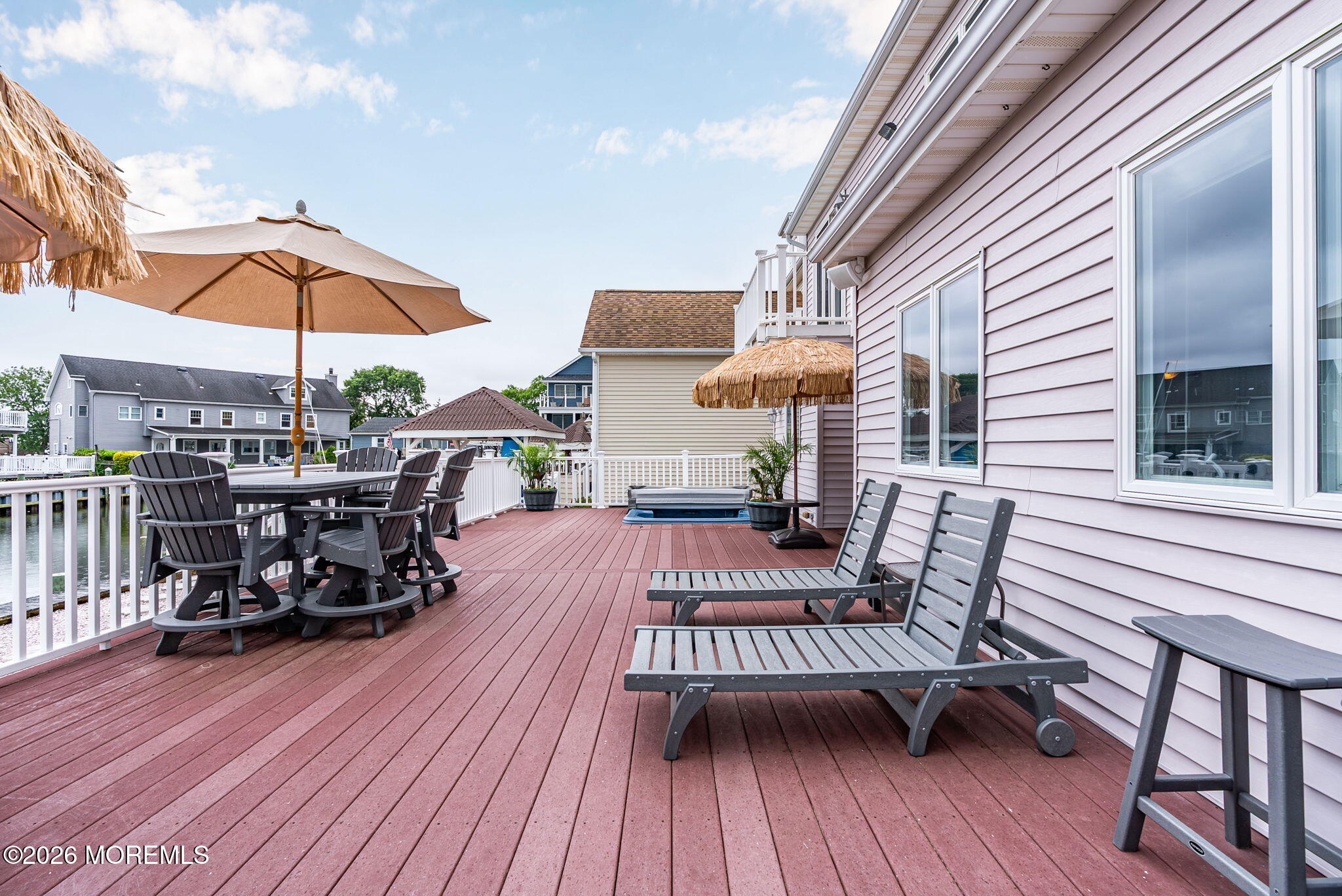 9 Cross Trees Road Brick, NJ 08723 - Photo 77 of 126 a view of a roof deck with table and chairs under an umbrella with wooden floor