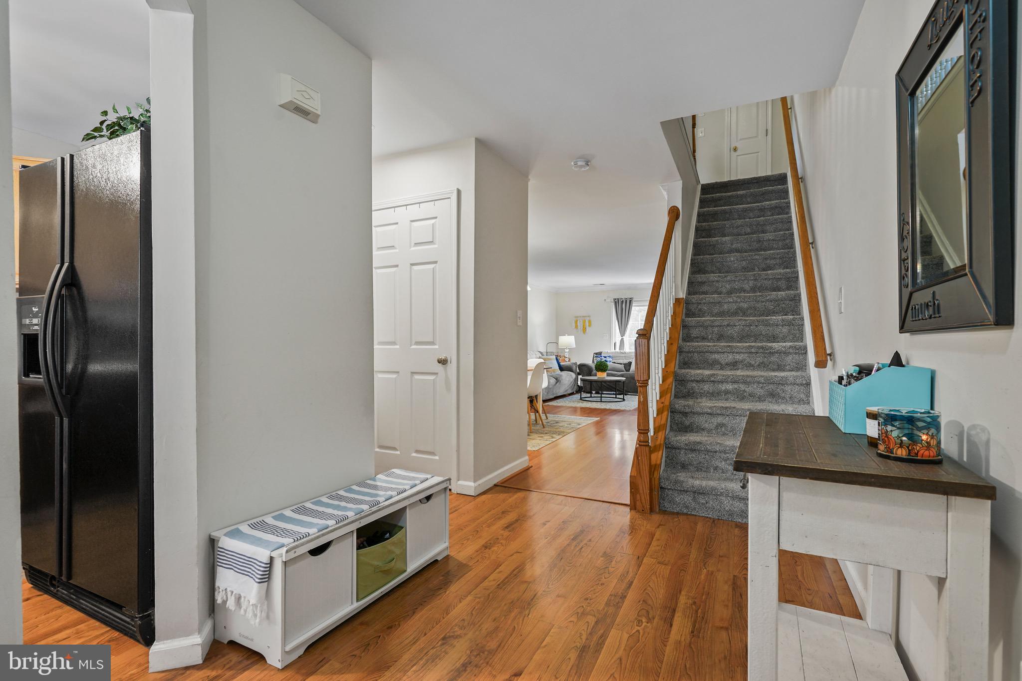 157 Setter Place Freehold, NJ 07728 - Photo 4 of 22 a hallway with wooden floor electronic appliances and stairs