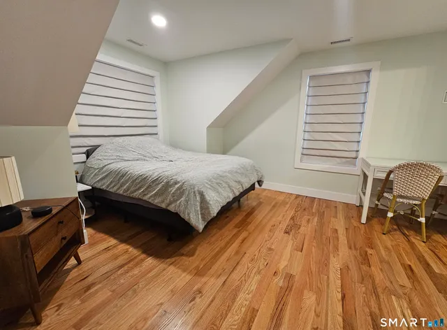 a spacious bedroom with a bed and a dresser