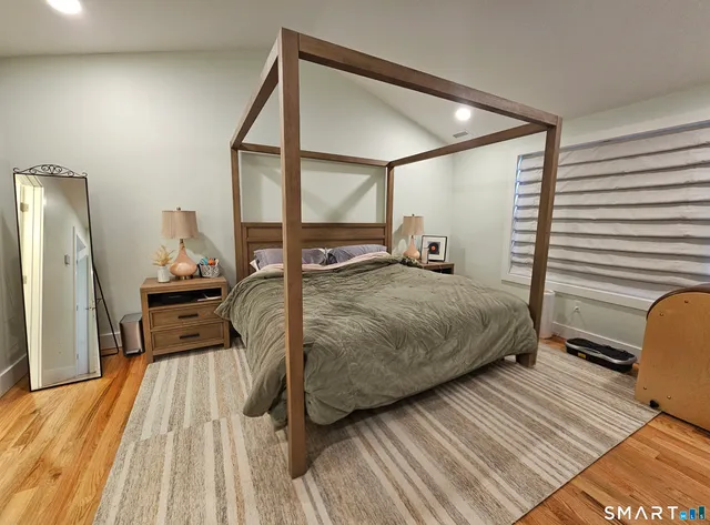 a spacious bedroom with a bed and a flat screen tv