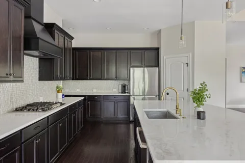 a kitchen with kitchen island a sink stove and refrigerator