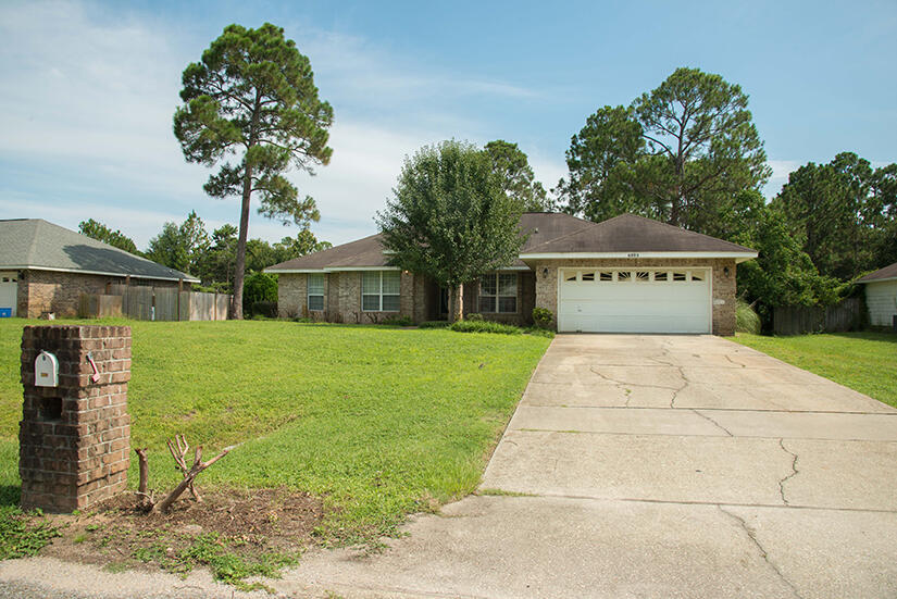 6805 Fernandina Road Navarre, FL 32566 - Photo 2 of 29 a front view of a house with garden
