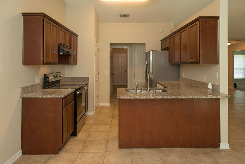 6805 Fernandina Road Navarre, FL 32566 - Photo 4 of 29 a kitchen with stainless steel appliances granite countertop a sink stove and microwave