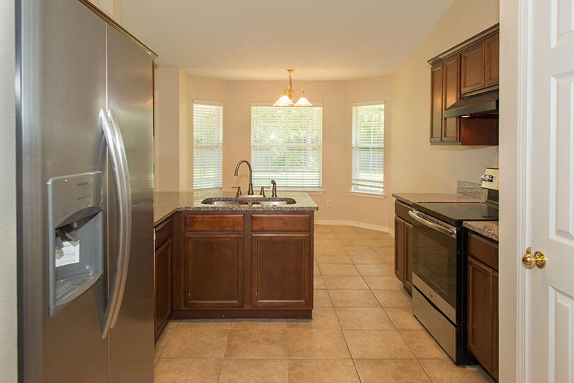 6805 Fernandina Road Navarre, FL 32566 - Photo 5 of 29 a kitchen with stainless steel appliances granite countertop a refrigerator and a stove