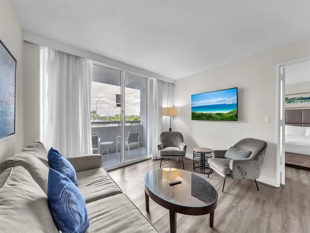 a living room with furniture and a floor to ceiling window