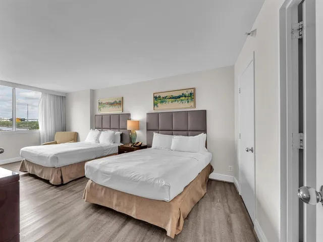 a bedroom with two beds and a night stand