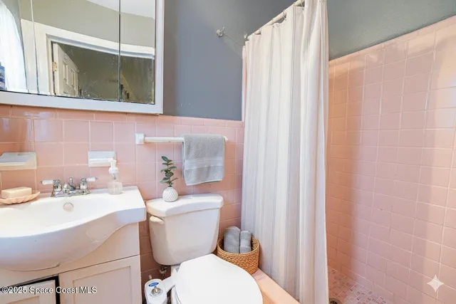 a bathroom with a sink a toilet and shower curtain
