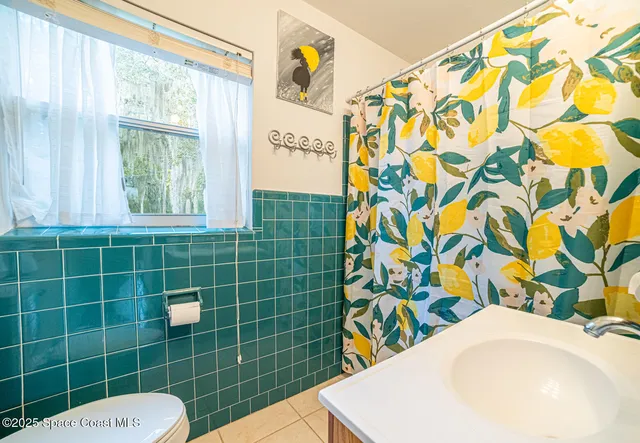 a bathroom with a sink toilet and a shower curtain