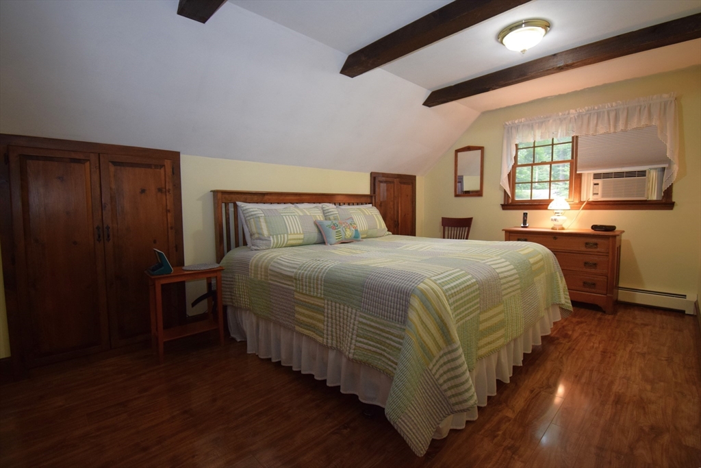 91 Ball Road Kingston, NH 03848 - Photo 23 of 42 a bedroom with a bed and wooden floor