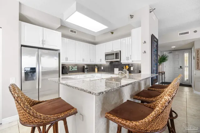 a kitchen with kitchen island granite countertop a sink table and chairs