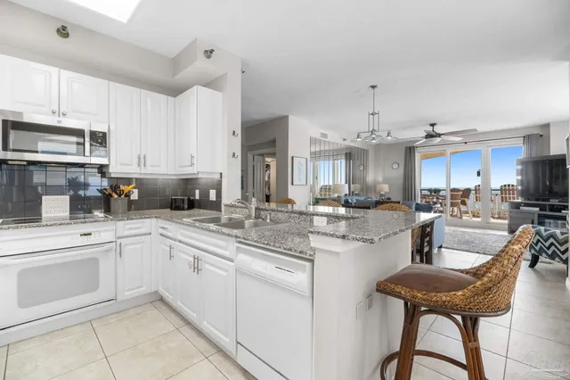 a kitchen with granite countertop a refrigerator and cabinets