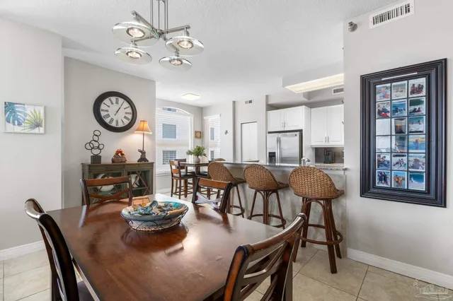 a dining room with wooden floor a chandelier a wooden table and chairs