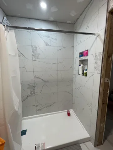 a white toilet sitting next to a bathroom sink and a shower