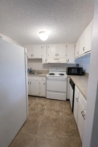 a kitchen with white cabinets stainless steel appliances and sink