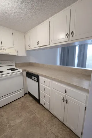 a kitchen with white cabinets and white appliances