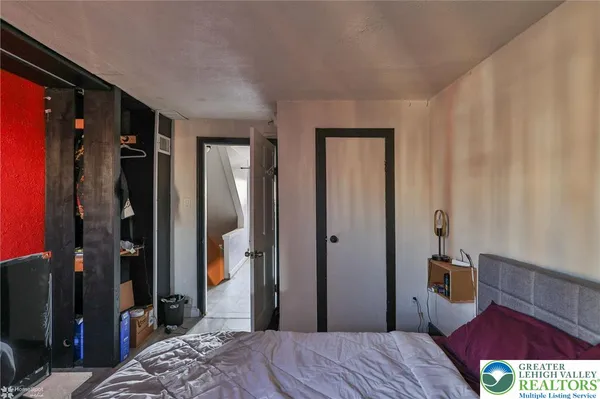 a bedroom with a bed and a large mirror