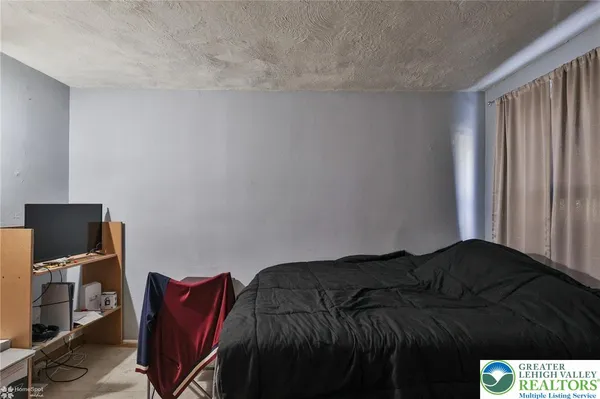 a bedroom with a bed and chair