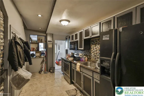 a kitchen with stainless steel appliances granite countertop a refrigerator a stove and a sink