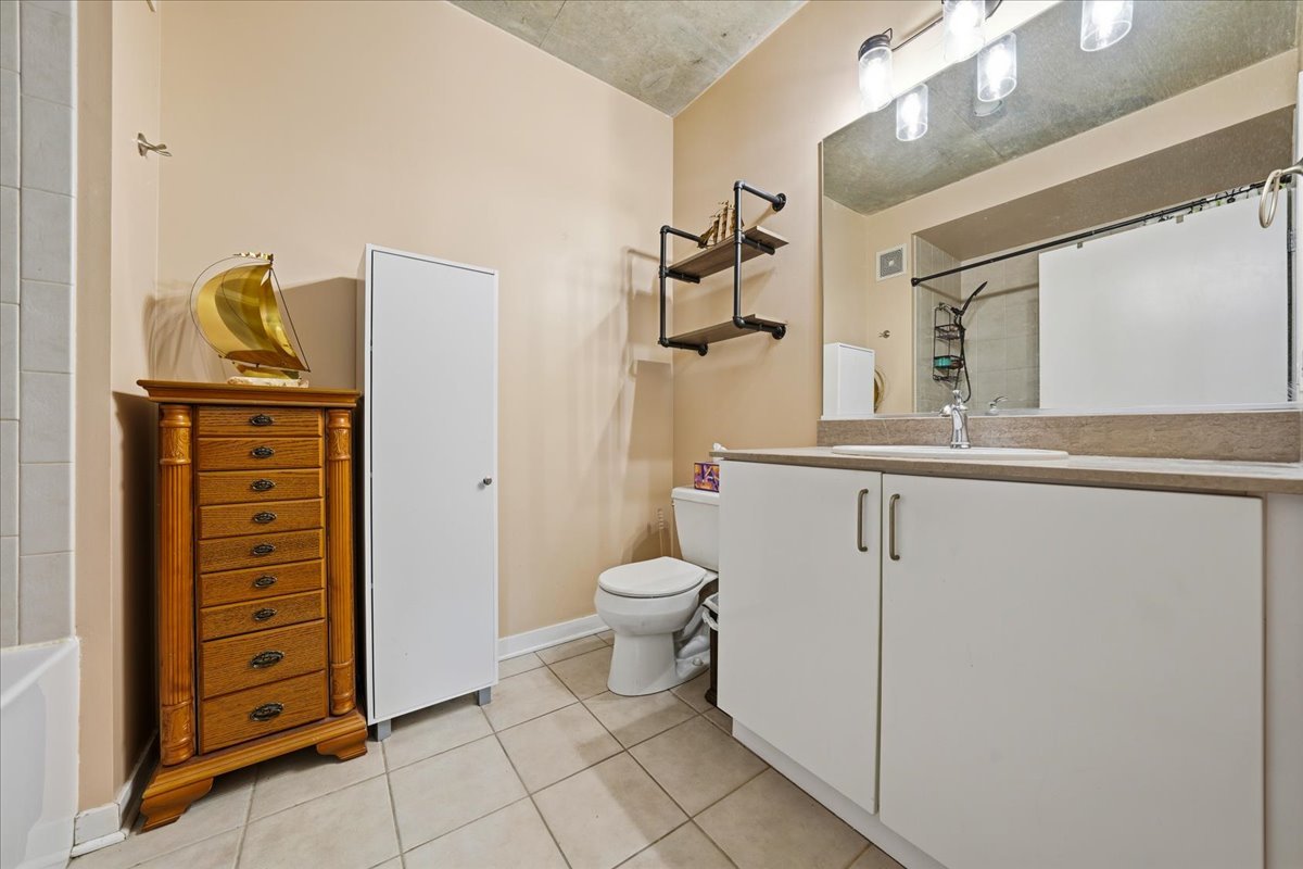 611 South Wells Street, Unit 1110 Chicago, IL 60607 - Photo 14 of 19 a bathroom with a toilet sink and shower