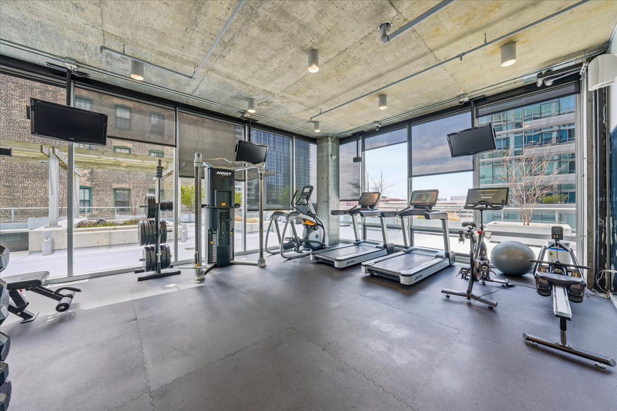 611 South Wells Street, Unit 1110 Chicago, IL 60607 - Photo 17 of 19 a room with gym equipment and a table