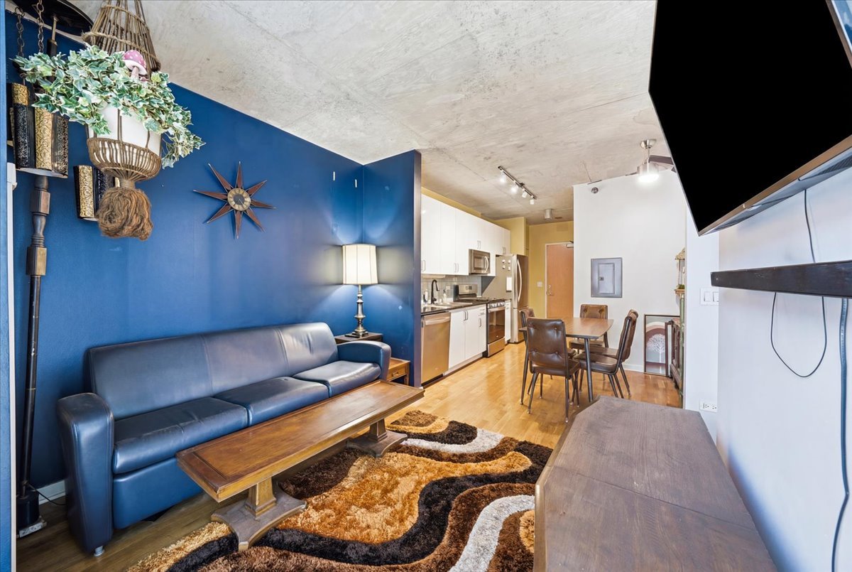 611 South Wells Street, Unit 1110 Chicago, IL 60607 - Photo 9 of 19 a living room with furniture gym equipment and a chandelier