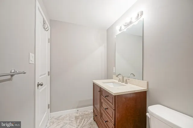 a bathroom with a sink mirror vanity and toilet