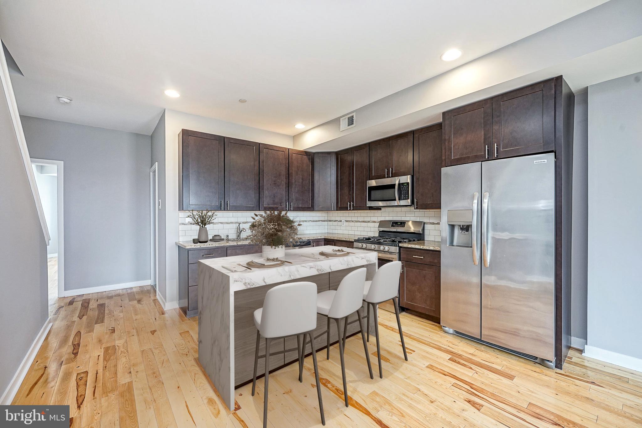 1011 Germantown Avenue, Unit B Philadelphia, PA 19123 - Photo 4 of 34 a kitchen with a refrigerator a stove top oven a sink and dishwasher with wooden floor