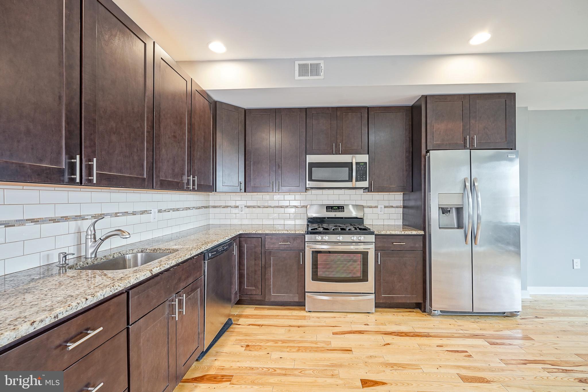 1011 Germantown Avenue, Unit B Philadelphia, PA 19123 - Photo 8 of 34 a kitchen with stainless steel appliances granite countertop a sink stove and refrigerator