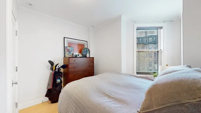 a bedroom with a bed and a painting on the wall