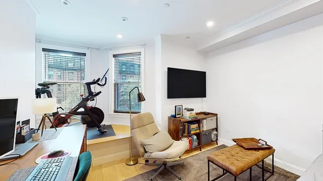 a living room with furniture a flat screen tv and a window