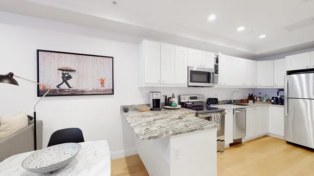 a kitchen with granite countertop appliances a sink and a refrigerator